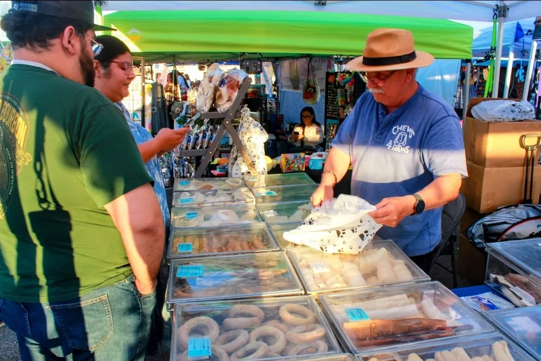 A vendor selling handmade dog treats to customers at Buckeye Night Market