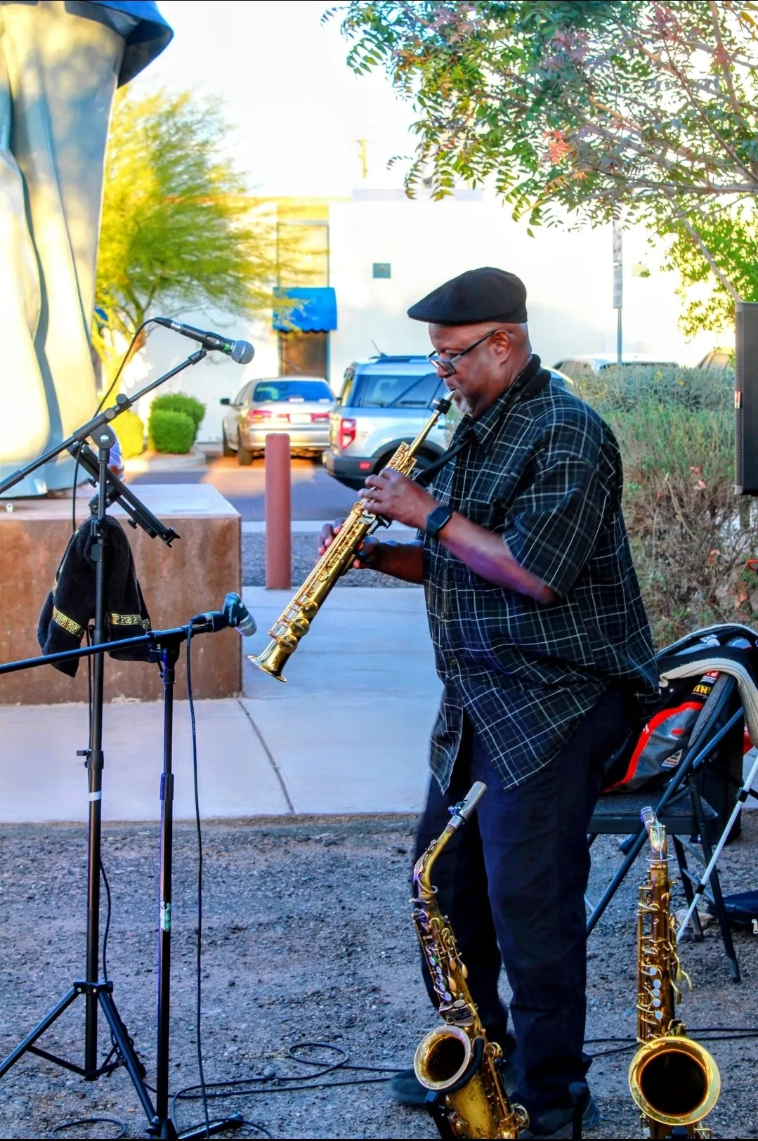 A saxophonist performing live at golden hour beside the Hobo Joe statue at Buckeye Night Market